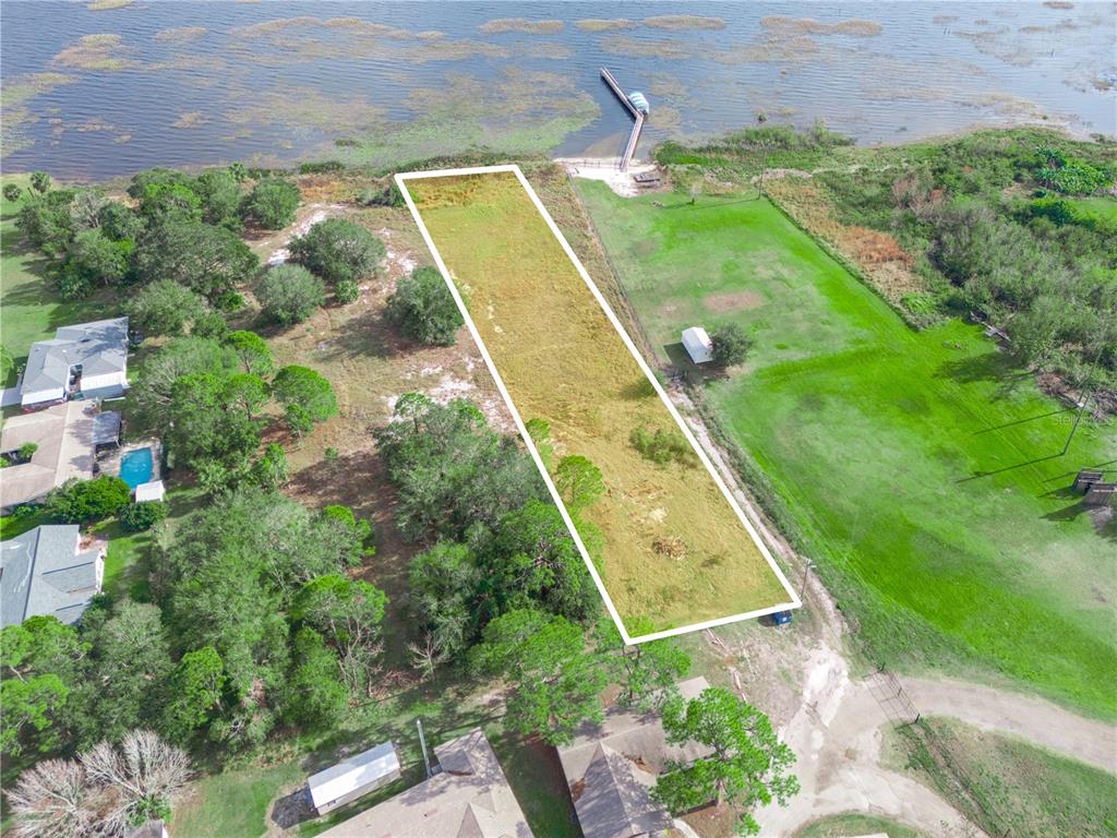 An aerial view shows a rectangular vacant lot extending to a lake with a dock — 0 S LAKESHORE LANE, LAKE WALES, FL