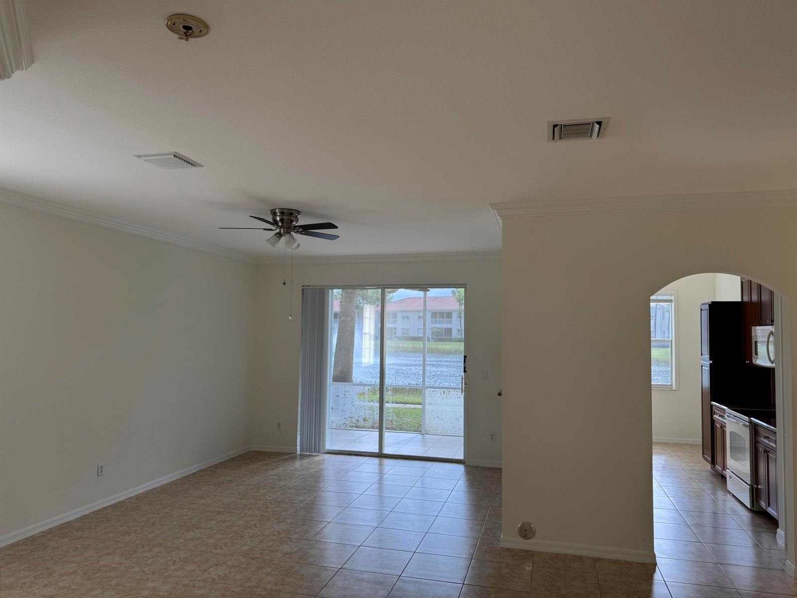 An open living area with tile floors, a ceiling fan, and a view of a lake — 2140 Wingate Bend, Wellington FL 33414, WELLINGTON, FL