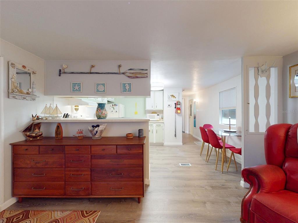 A wooden dresser sits in a living area next to a kitchen and dining space — 2201 S RIDGEWOOD AVENUE UNIT 8, EDGEWATER, FL