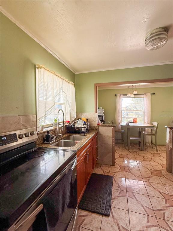 A kitchen with green walls, wood cabinets, and a dining area visible through an opening — 2403 GOLFVIEW STREET, LAKELAND, FL