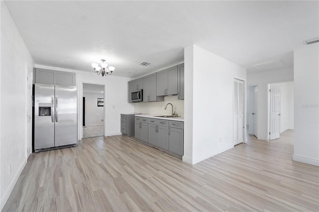 A kitchen with gray cabinets, stainless steel appliances, and light wood-look flooring — 16011 NW 40TH COURT, MIAMI GARDENS, FL