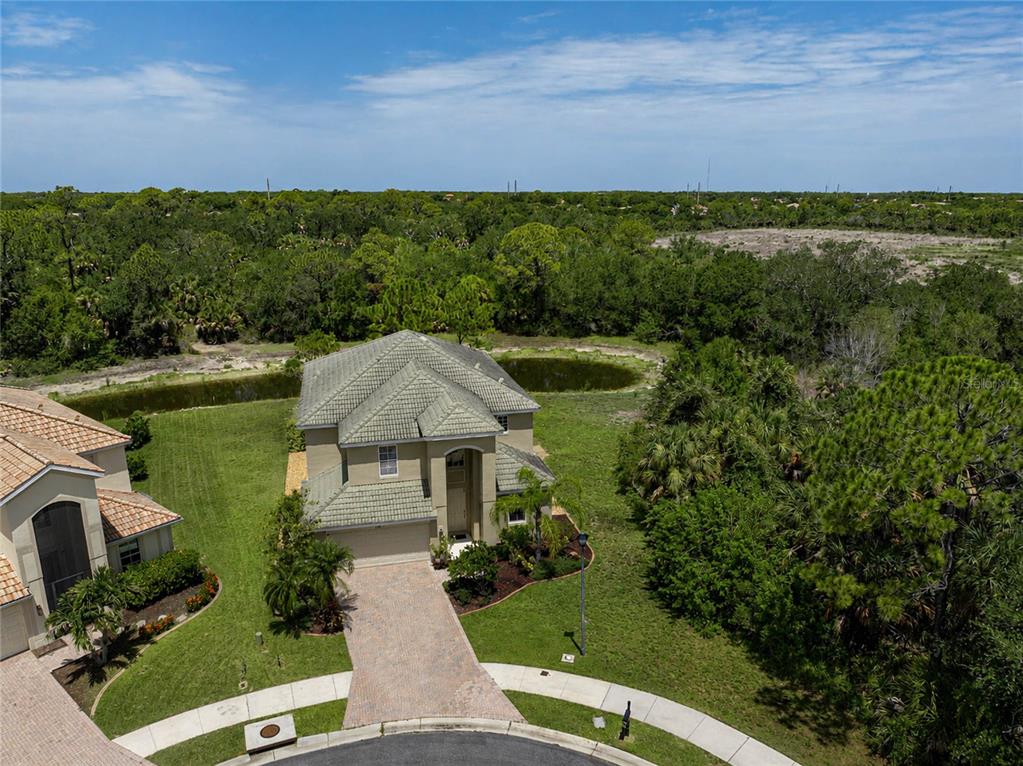 An aerial view shows a two-story house with a tiled roof and a paved driveway — 11691 BREADFRUIT LANE, VENICE, FL