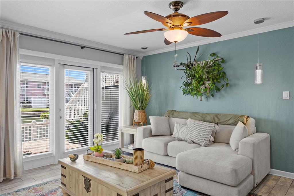 A living room features a light-colored sectional sofa, a wooden coffee table, and a teal wall — 5175 COQUINA KEY DRIVE SE UNIT A, ST PETERSBURG, FL