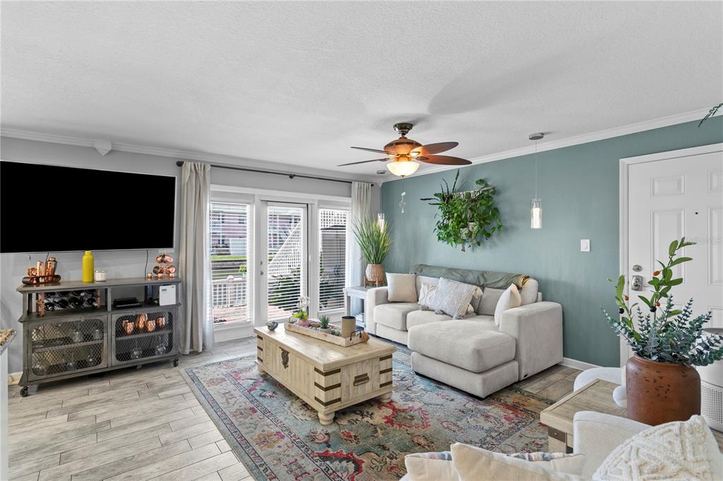 A living room features a light-colored sectional sofa, a wooden coffee table, and blue walls — 5175 COQUINA KEY DRIVE SE UNIT A, ST PETERSBURG, FL