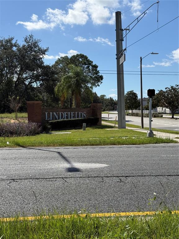 A brick entrance sign for Lindfields stands beside a road with a utility pole nearby — 3245 SUSTAINABLE WAY, KISSIMMEE, FL