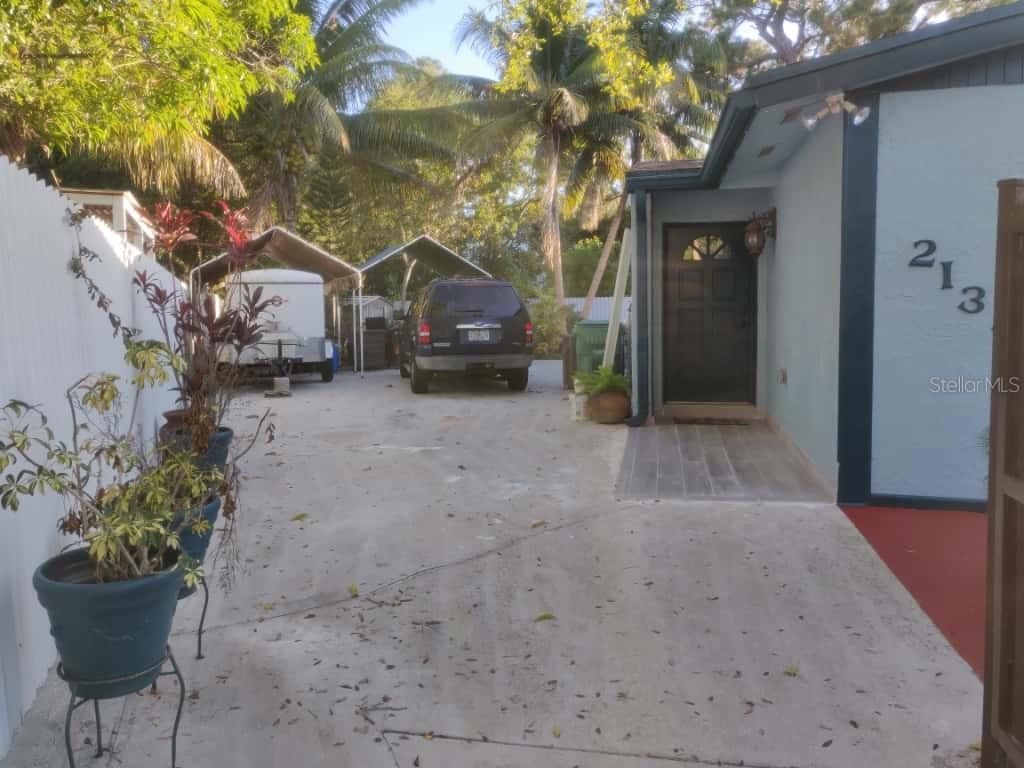 A concrete driveway leads to the front entrance of a house with a parked SUV — 21348 NW 40TH CIRCLE COURT, MIAMI GARDENS, FL