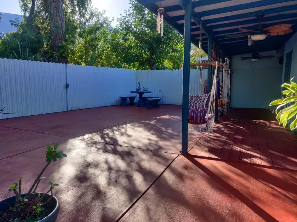 A patio with a covered wooden deck, a hammock, and a small table with chairs — 21348 NW 40TH CIRCLE COURT, MIAMI GARDENS, FL