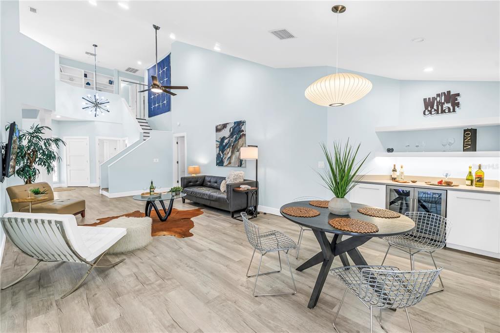 A bright, open-concept living and dining area features light blue walls and wood-look flooring — 355 RED CEDAR COURT NE, ST PETERSBURG, FL