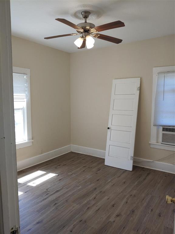 An empty bedroom features wood-look flooring, a ceiling fan, and a detached door leaning against wall — 1924 30TH STREET S, ST PETERSBURG, FL