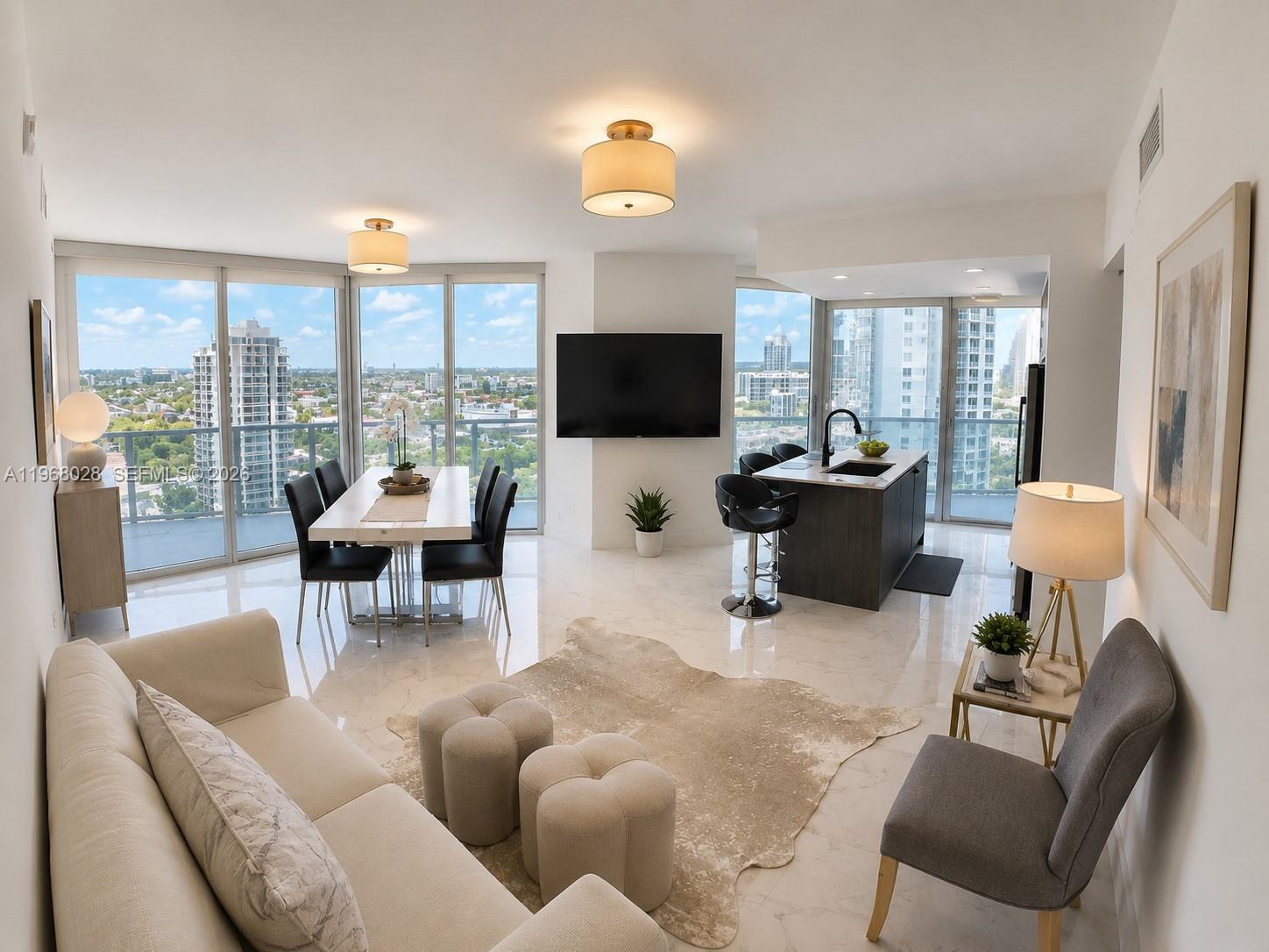 A modern kitchen features a white island with black chairs and stainless steel appliances — 488 NE 18th St # 2001, Miami FL 33132, MIAMI, FL