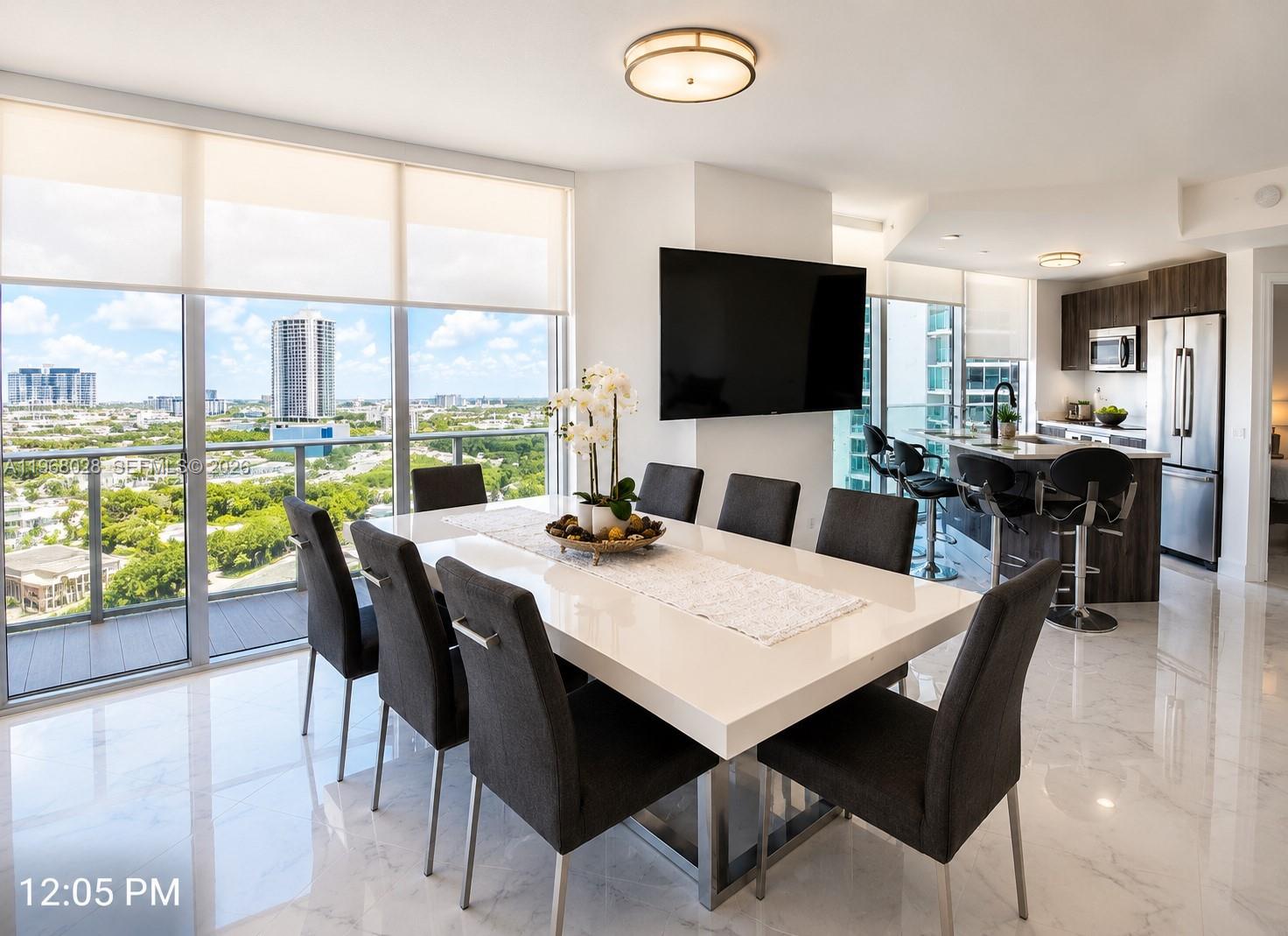 A modern bedroom features a bed, two chairs, a television, and a balcony with city views — 488 NE 18th St # 2001, Miami FL 33132, MIAMI, FL