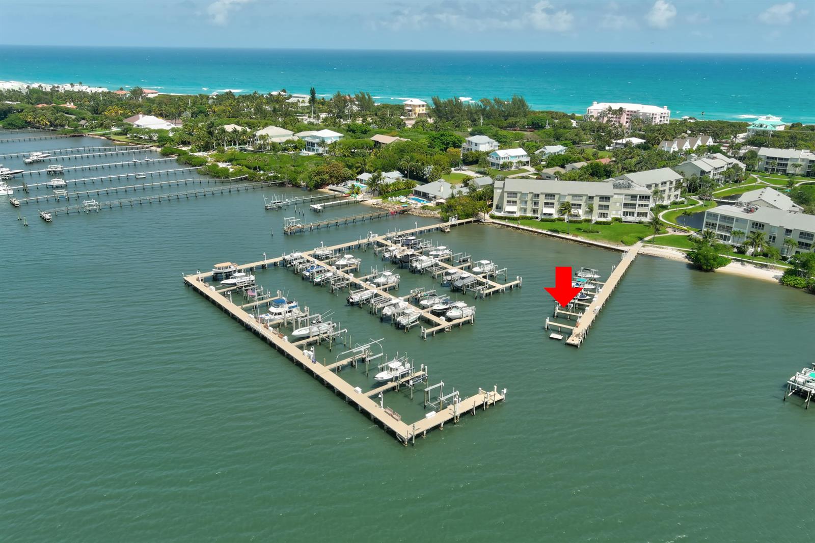 An aerial view shows a marina with multiple boat slips and a red arrow pointing down — 1555 NE Ocean Boulevard # 205, Stuart FL 34996, STUART, FL