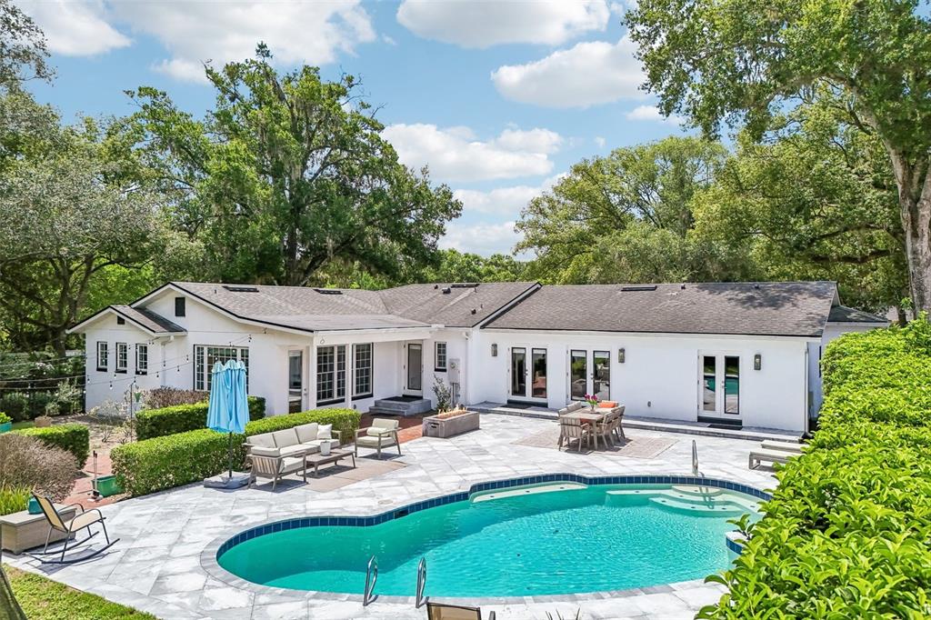 A white house with a swimming pool and patio area surrounded by mature trees — 1271 PALMER AVENUE, WINTER PARK, FL