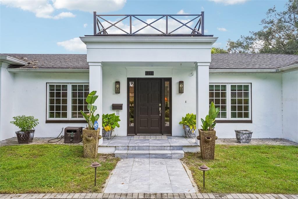 The exterior of a white house features a dark front door and a rooftop railing — 1271 PALMER AVENUE, WINTER PARK, FL