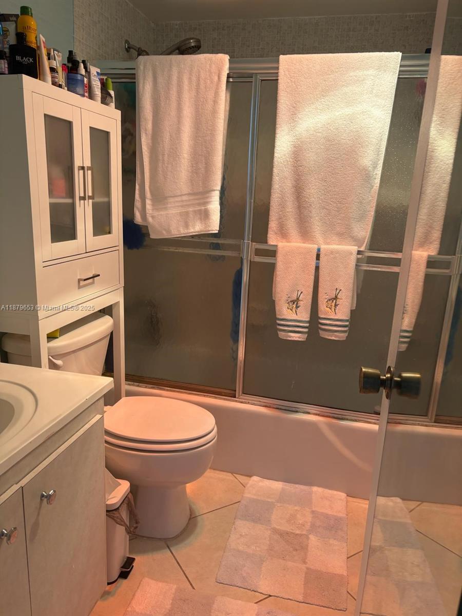 A bathroom features a white storage cabinet over the toilet and a glass-enclosed shower — 1965 S Ocean Dr # 7D, Hallandale Beach FL 33009, HALLANDALE BEACH, FL