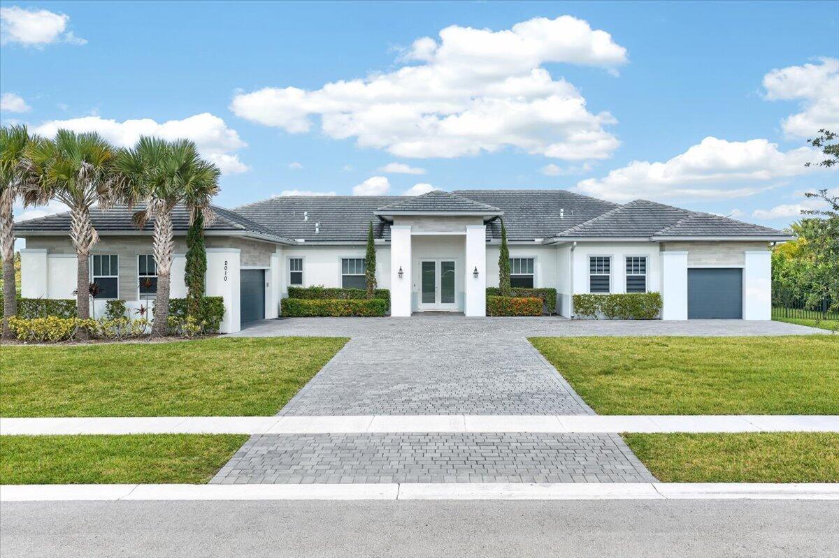 A single-story house with a gray tiled roof, white exterior, and a paved driveway — 2010 Meadows Drive, Davie FL 33324, DAVIE, FL