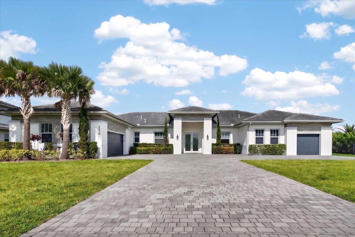 A single-story house with a paved driveway, palm trees, and a gray tiled roof — 2010 Meadows Drive, Davie FL 33324, DAVIE, FL