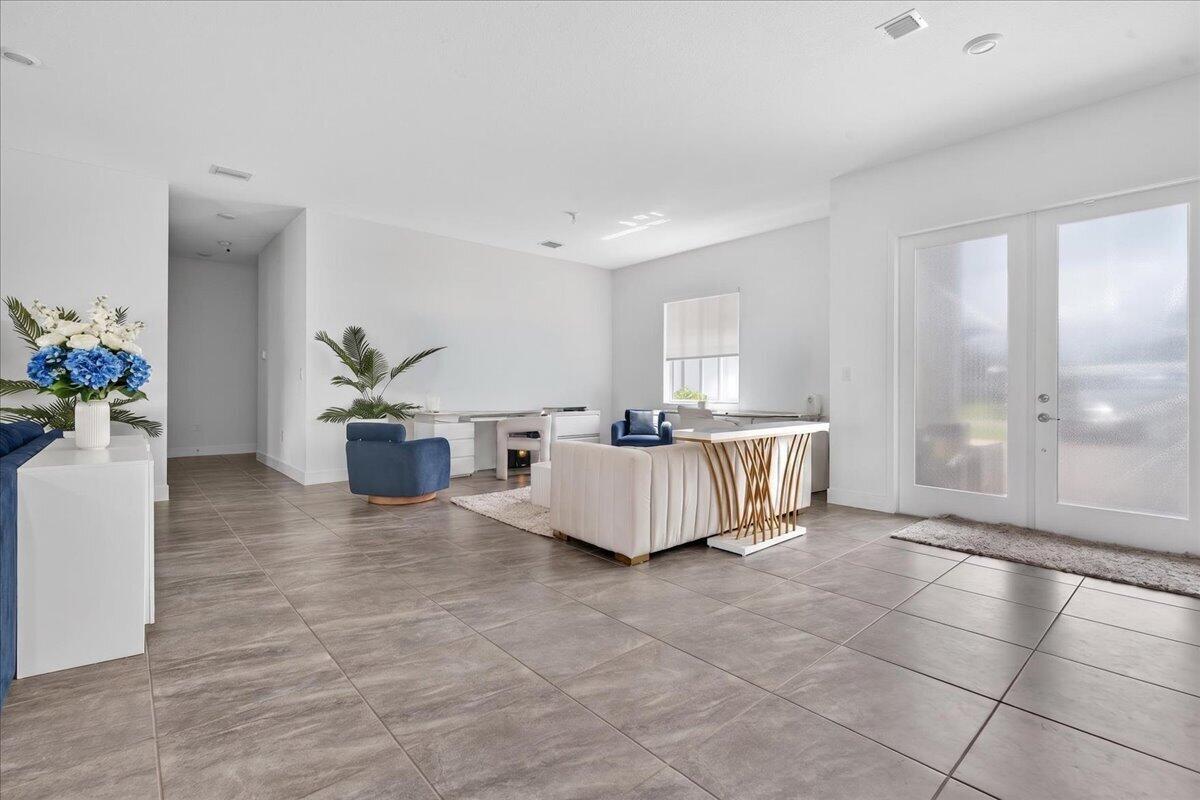 A bright, open-concept living area features large light-colored floor tiles and white walls — 2010 Meadows Drive, Davie FL 33324, DAVIE, FL