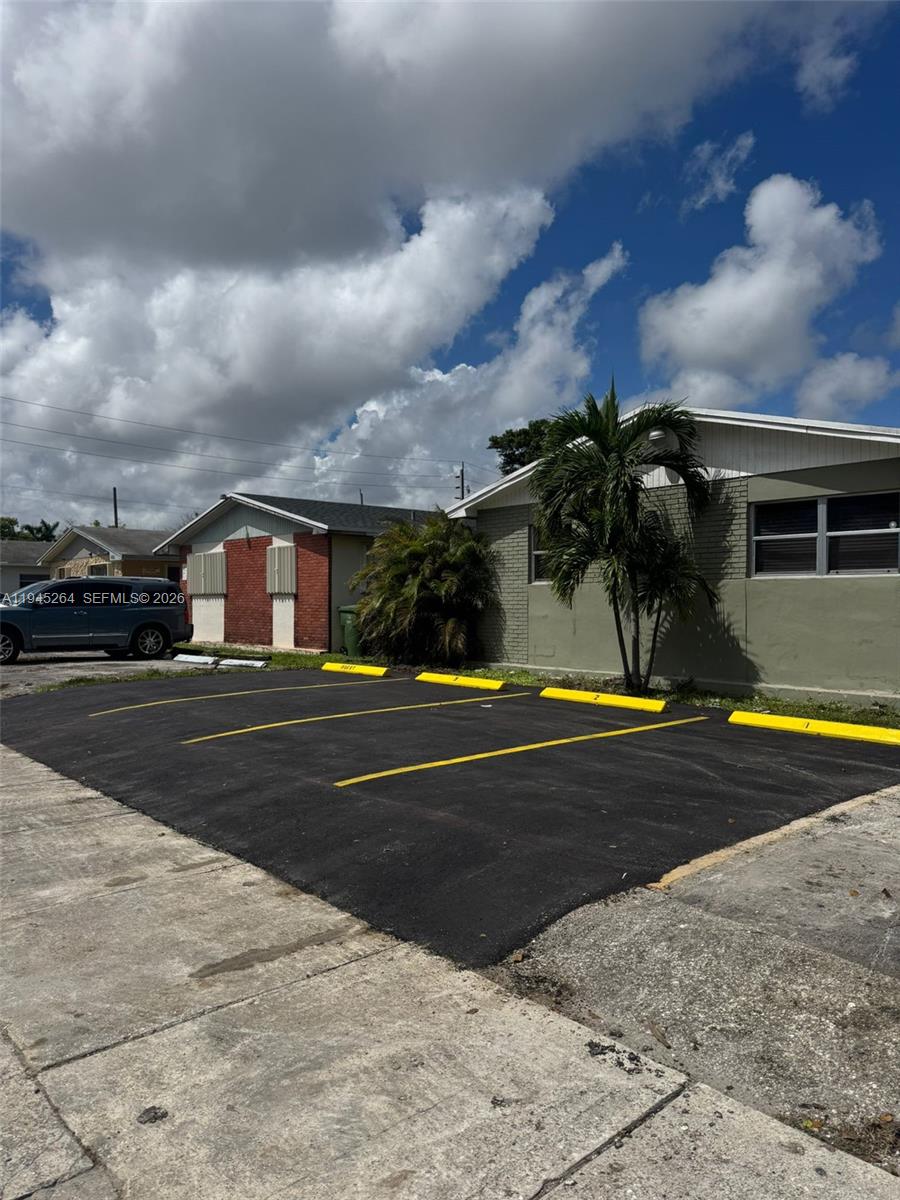 A paved parking lot with marked spaces sits in front of two single-story residential buildings — 844 SW 10th St, Hallandale Beach FL 33009, HALLANDALE BEACH, FL