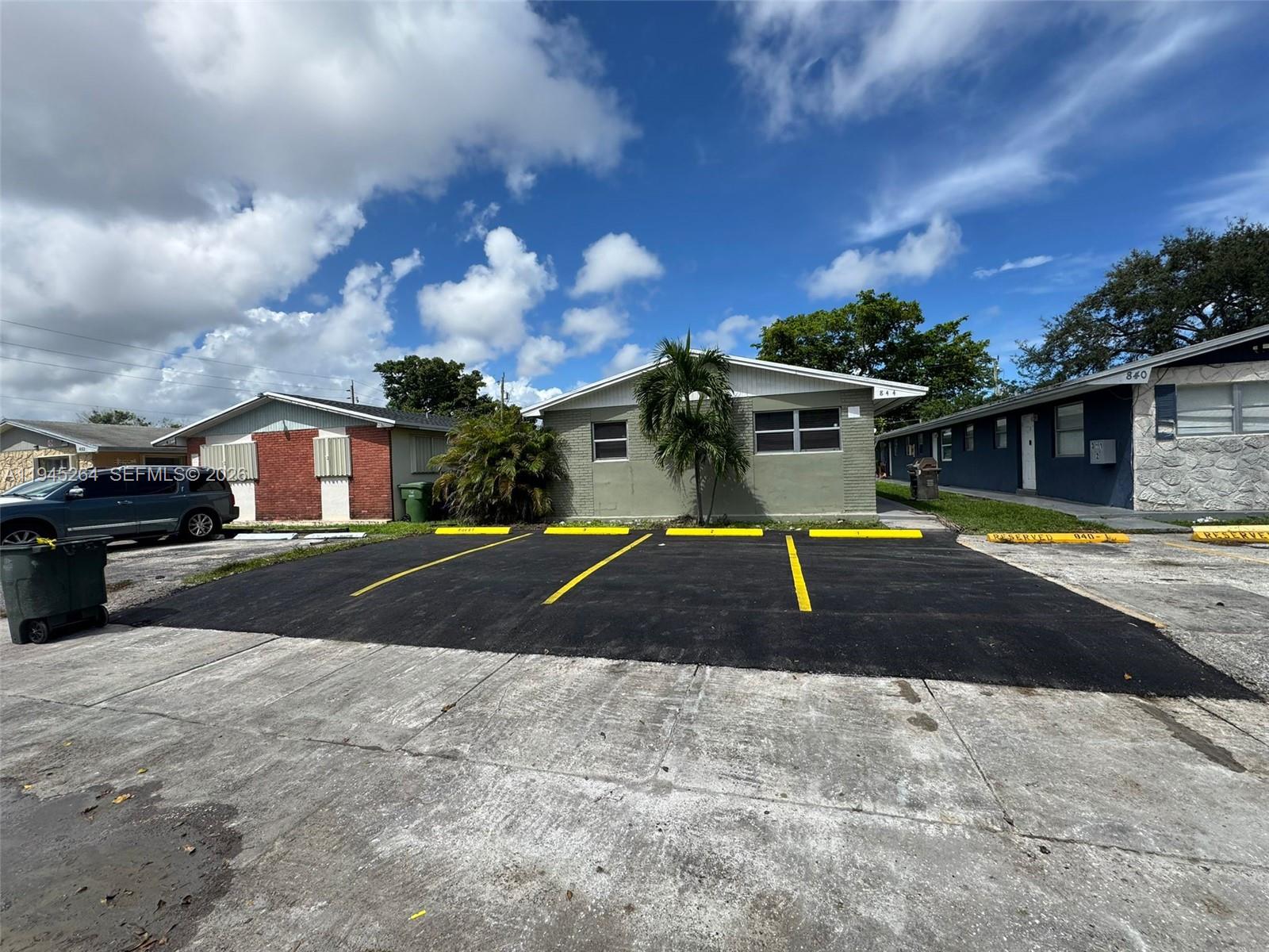 A paved parking area sits in front of a single-story building with a palm tree — 844 SW 10th St, Hallandale Beach FL 33009, HALLANDALE BEACH, FL