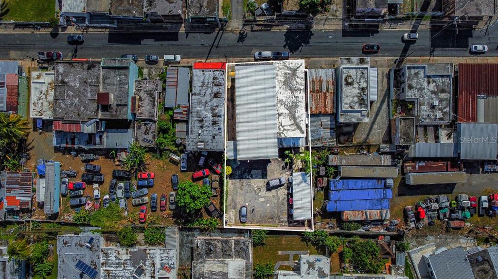 An aerial view shows a rectangular commercial property with a metal roof and paved parking lot — 435 URB. HERMANAS DAVILA, BAYAMON, PR