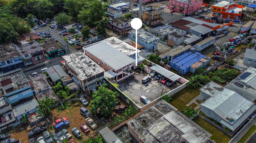 An aerial view shows a commercial building with a large paved parking lot and carport — 435 URB. HERMANAS DAVILA, BAYAMON, PR