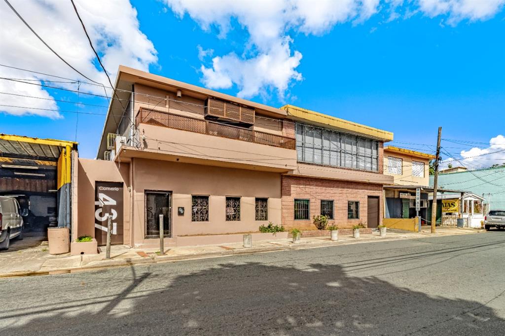 A two-story tan building with a street-level entrance and a second-floor balcony — 435 URB. HERMANAS DAVILA, BAYAMON, PR