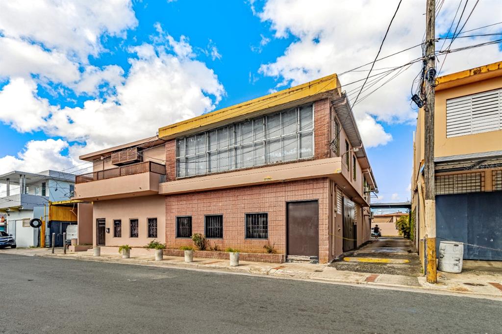 A two-story building with a brick facade, large upper windows, and a side driveway — 435 URB. HERMANAS DAVILA, BAYAMON, PR