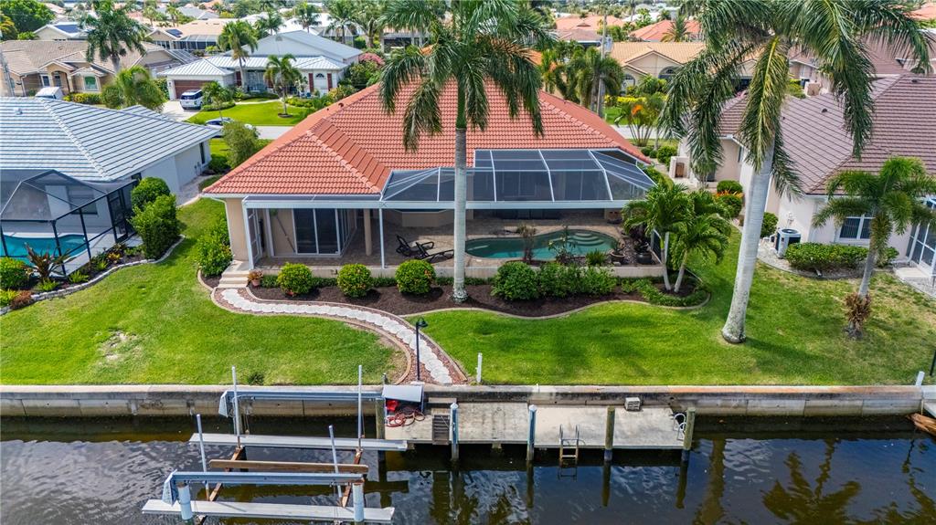 A single-story house with a terracotta tile roof, palm trees, and a concrete driveway — 1020 VIA FORMIA, PUNTA GORDA, FL