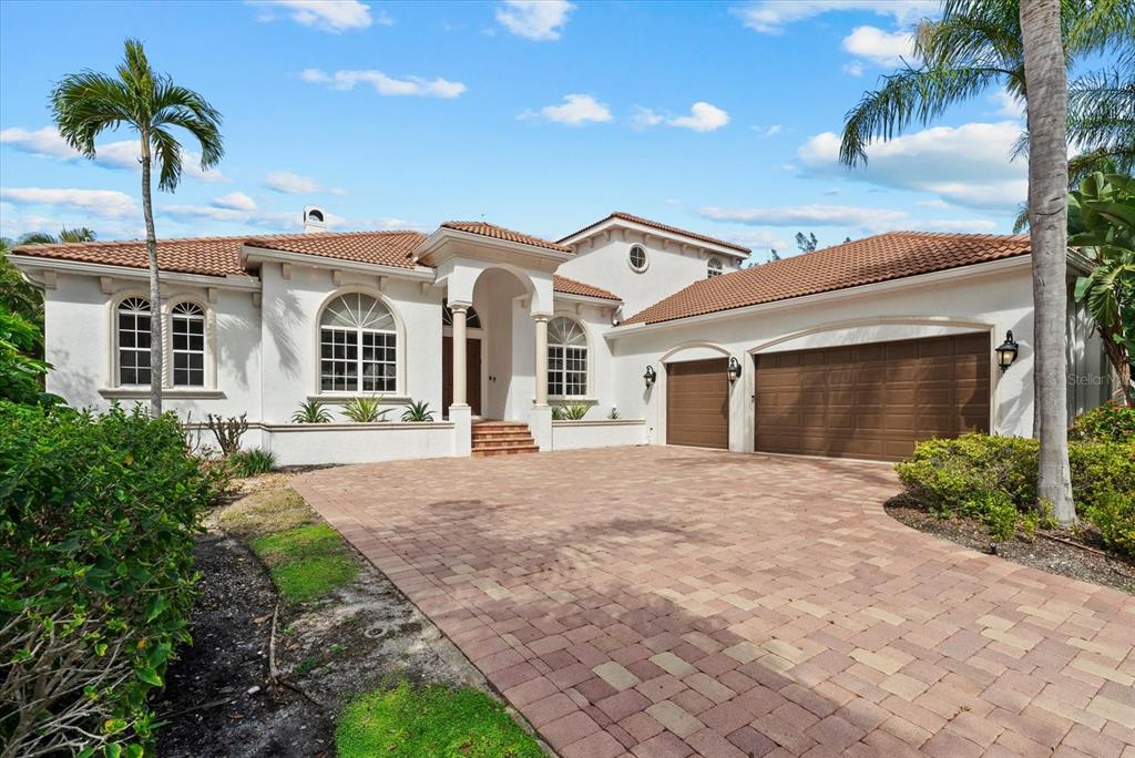 A white stucco house with a tiled roof, arched windows, and a brick paver driveway — 3508 LA PALOMA AVENUE, SARASOTA, FL