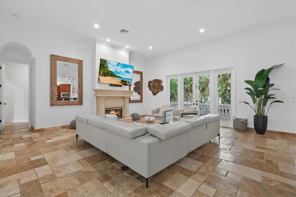 A living room features a large sectional sofa, a fireplace with a television, and tile flooring — 3508 LA PALOMA AVENUE, SARASOTA, FL