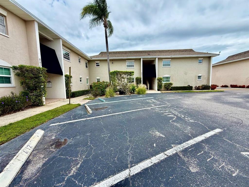 An exterior view of a two-story apartment building with a paved parking lot in front — 8801 BAY POINTE DRIVE UNIT 102, TAMPA, FL