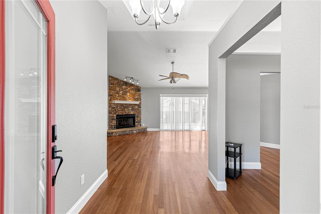 An entryway leads into a living room with hardwood floors and a stone fireplace — 10485 SE 42ND COURT, BELLEVIEW, FL