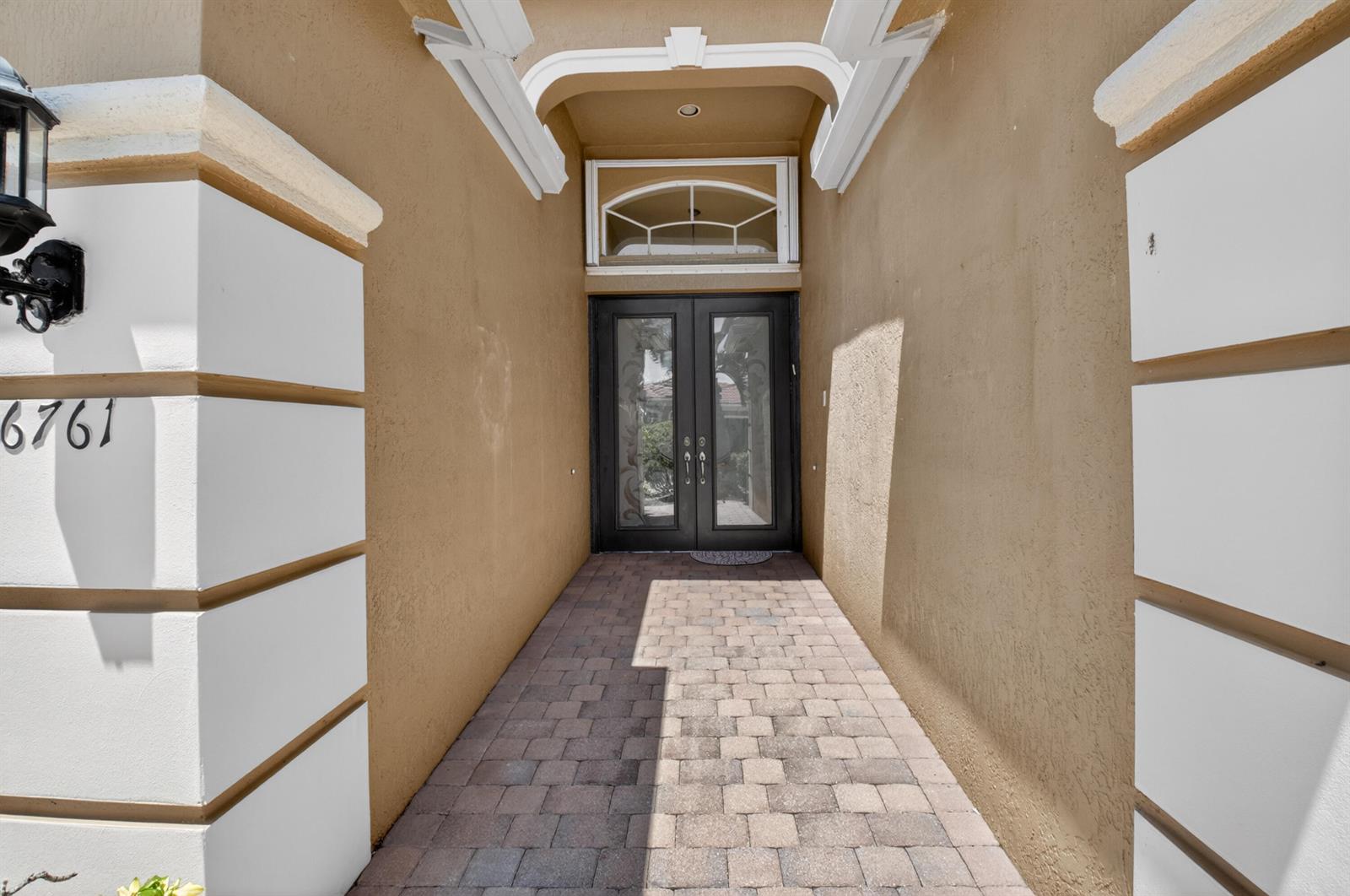 A paved walkway leads to a double glass front door under a decorative arched entryway — 6761 Pisano Drive, Lake Worth FL 33467, LAKE WORTH, FL