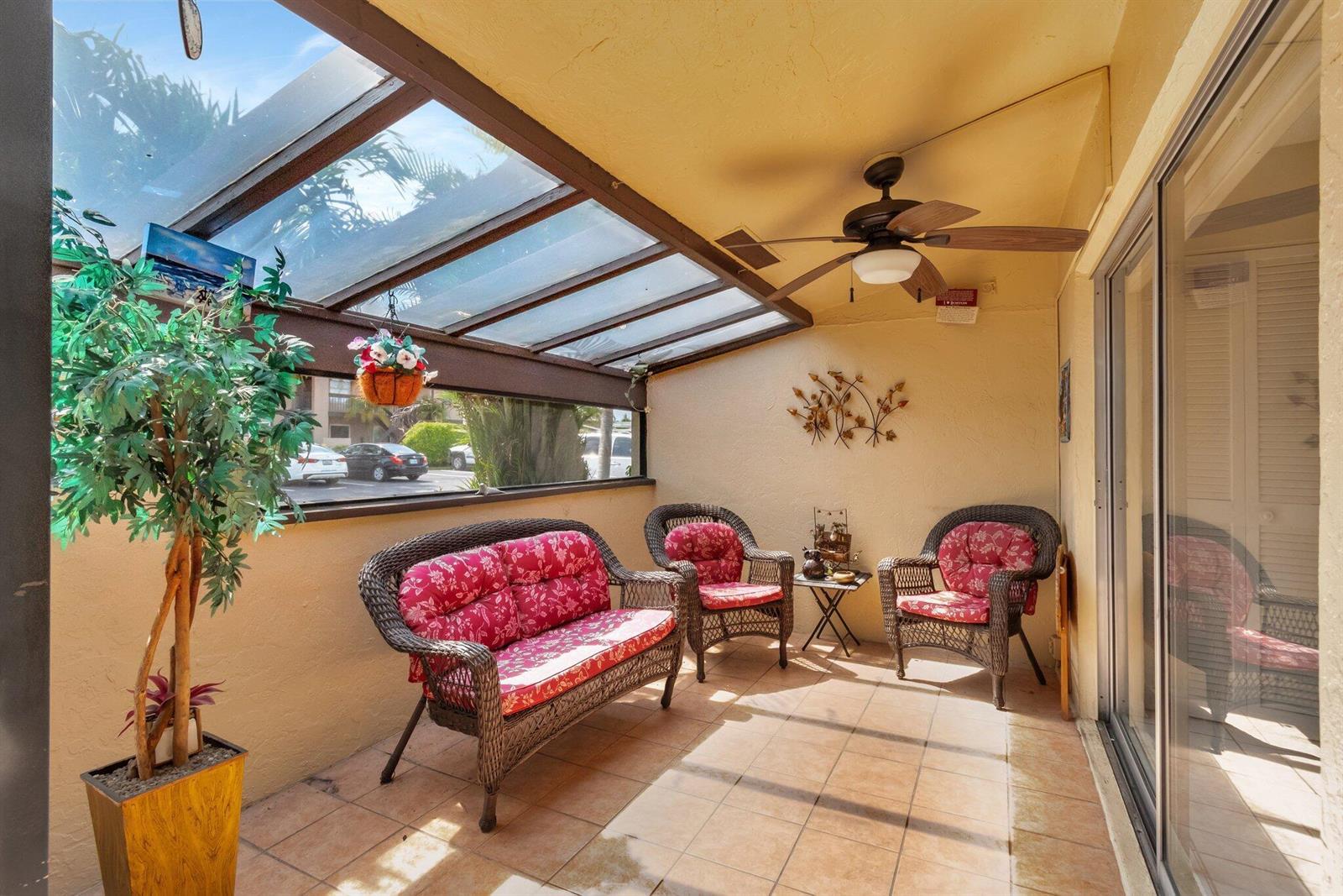 A sunroom with a glass roof, tile flooring, wicker furniture, and a ceiling fan — 13691 Via Aurora, Delray Beach FL 33484, DELRAY BEACH, FL