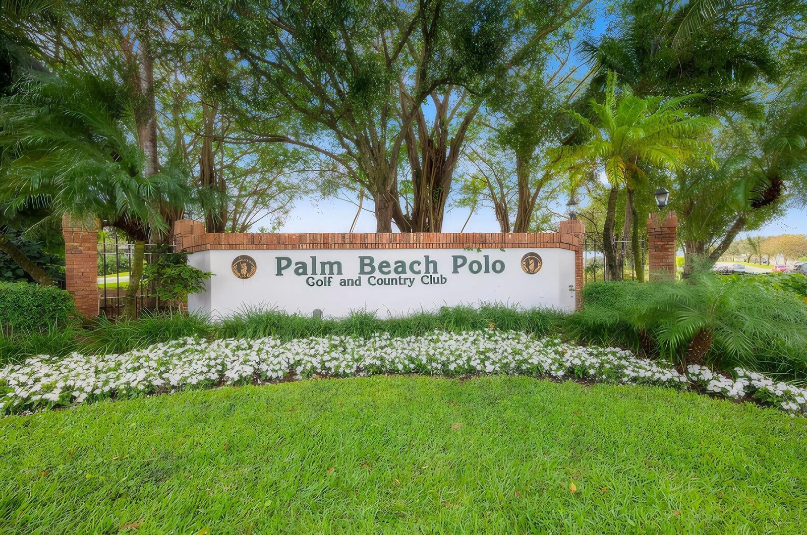 A sign for the Palm Beach Polo Golf and Country Club stands behind white flowers — 11397 Pond View Drive # E103, Wellington FL 33414, WELLINGTON, FL