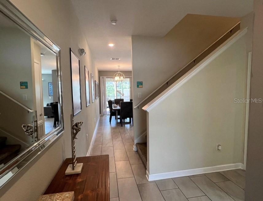 A foyer with tile flooring leads to a dining area past a staircase with railing — 420 OCEAN COURSE AVENUE, DAVENPORT, FL