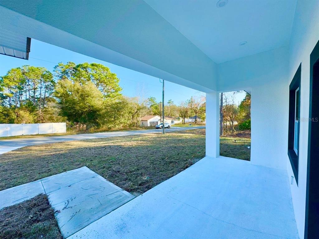 A covered concrete porch overlooks a grassy yard and a residential street — 7168 N DEBORAH TERRACE, CITRUS SPRINGS, FL