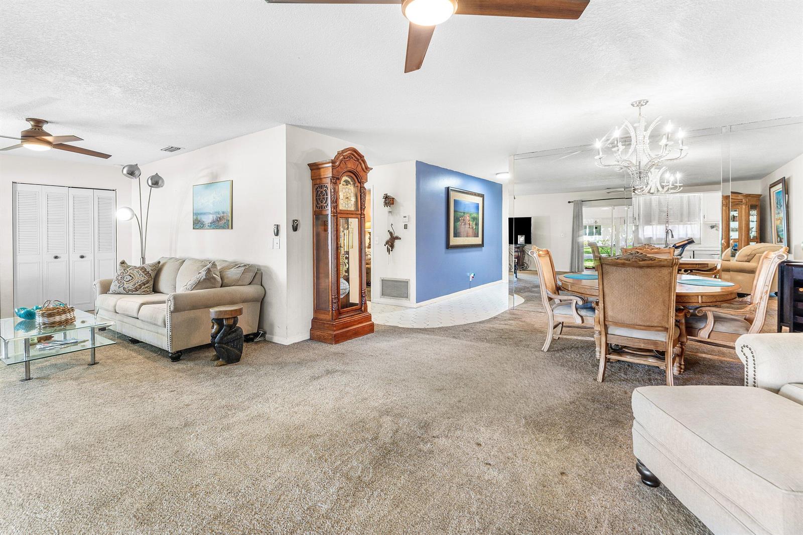 A living and dining area features carpeted floors, a grandfather clock, and a blue wall — 852 Salem Lane, Lake Worth FL 33467, LAKE WORTH, FL
