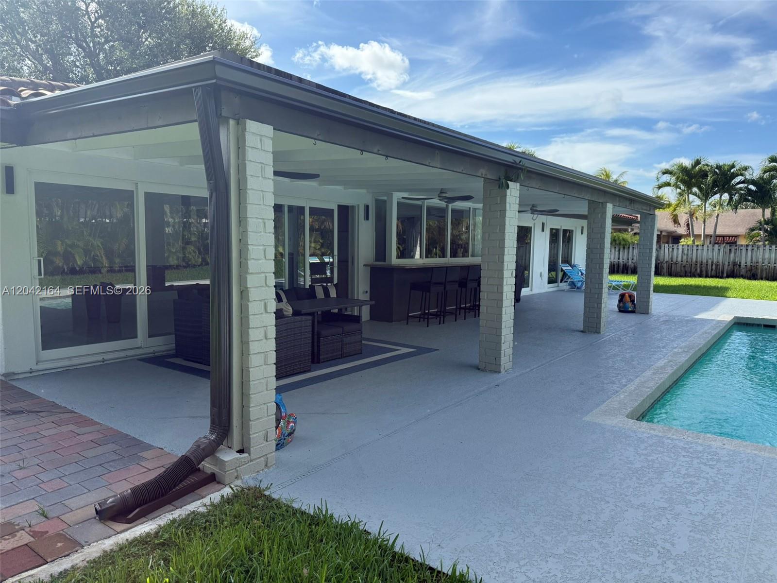 A covered patio features brick columns, a bar area, and a pool deck — 13461 SW 98th Pl # 13461, Miami FL 33176, MIAMI, FL