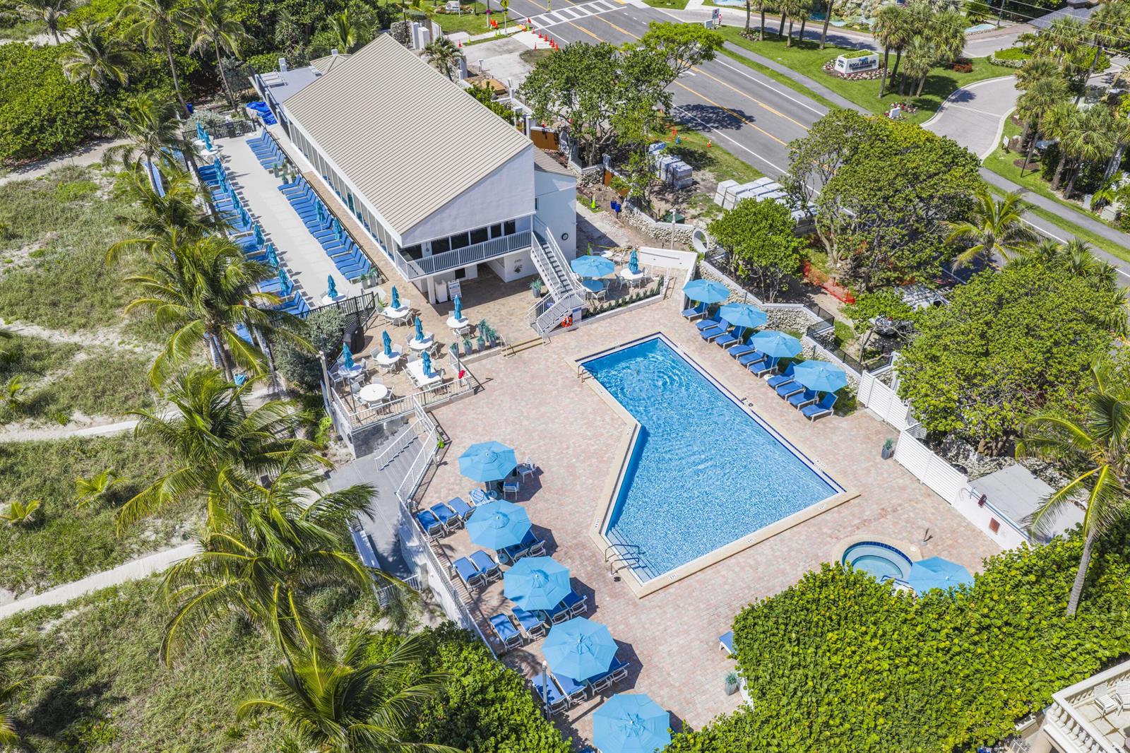 An aerial view shows a building with a pool, lounge chairs, and umbrellas — 4748 S Ocean Boulevard # 502, Highland Beach FL 33487, HIGHLAND BEACH, FL