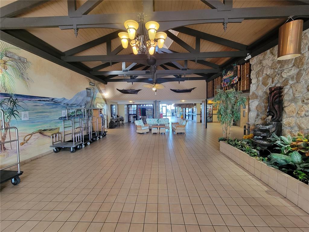 A hotel lobby features a tiled floor, vaulted wood-beam ceiling, mural, and stone water feature — 2301 S ATLANTIC AVENUE UNIT 238, DAYTONA BEACH, FL