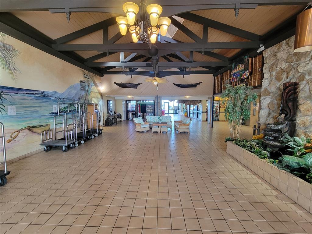 A spacious hotel lobby features a tiled floor, vaulted ceiling, mural, and indoor water feature — 2301 S ATLANTIC AVENUE UNIT 238, DAYTONA BEACH, FL