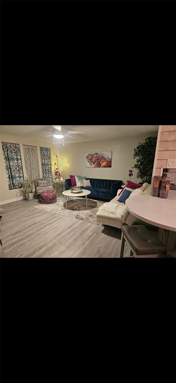 A living room features a blue sofa, a white coffee table, and light wood flooring — 250 CHAMBER STREET NW, PORT CHARLOTTE, FL