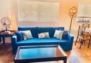 A living room features a blue sofa, a dark coffee table, and a floor lamp — 3206 W AZEELE STREET UNIT 220, TAMPA, FL