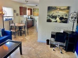 A living area features a blue sofa, a dining table, and a desk with a chair — 3206 W AZEELE STREET UNIT 220, TAMPA, FL