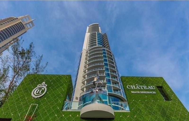 A low-angle view shows the exterior of the Chateau Beach Residences building with green walls — 17475 Collins Ave # 904, Miami Beach FL 33160, MIAMI BEACH, FL