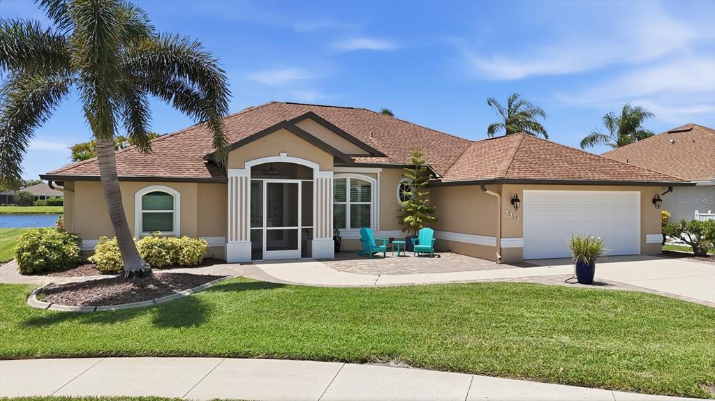 A single-story house with a tan exterior, a screened entryway, and a two-car garage — 5376 OAKMONT COURT, NORTH PORT, FL