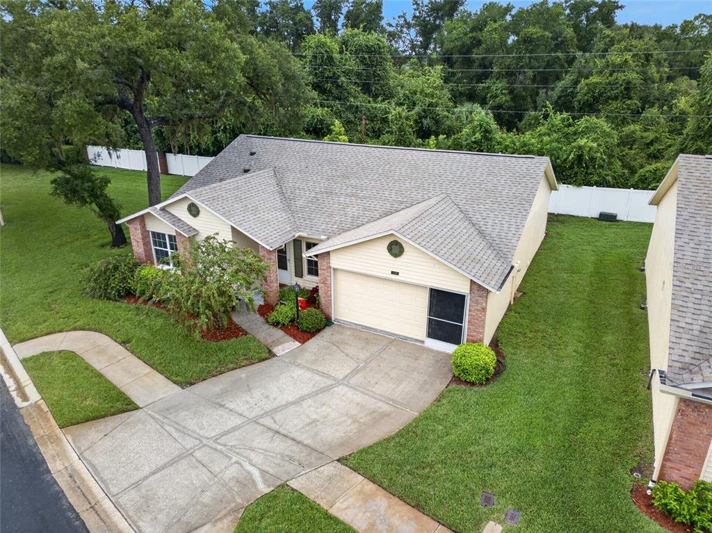 An aerial view of a single-story house with a concrete driveway and a grassy yard — 4949 BOSTONIAN LOOP, NEW PORT RICHEY, FL