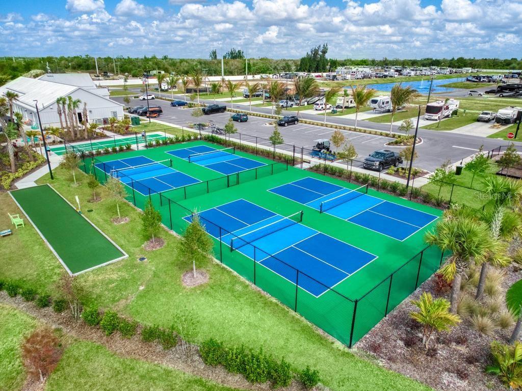 An aerial view shows a colorful playground with slides and metal roofs inside a fenced area — 31 HORIZON ROAD, PUNTA GORDA, FL